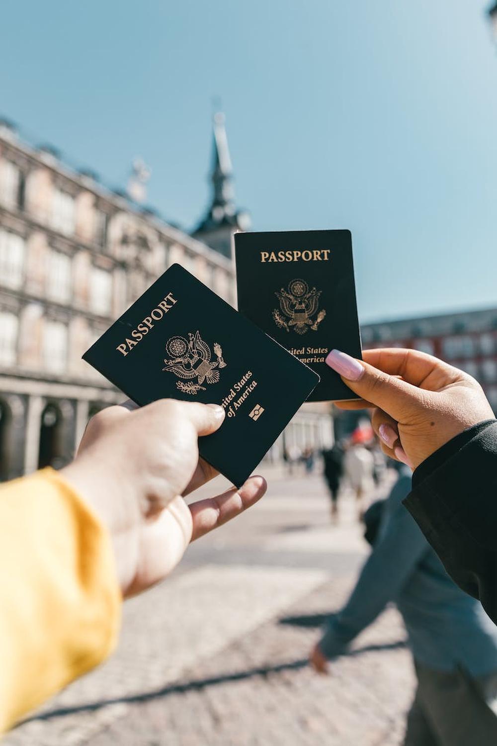 anonymous_tourists_showing_us_passports_on_street_