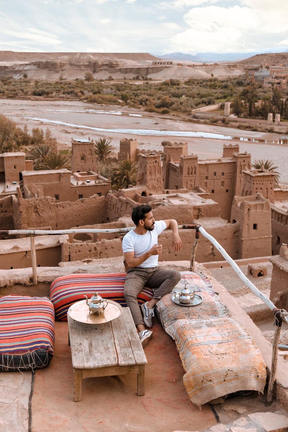 man_sitting_on_top_of_the_building_while_looking_t