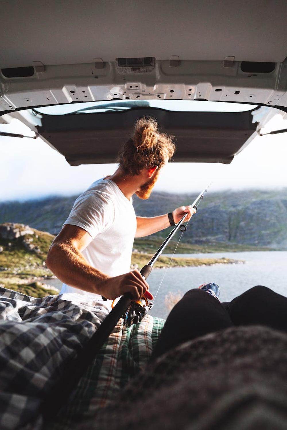 man_with_a_beard_fishing_out_of_a_camping_van