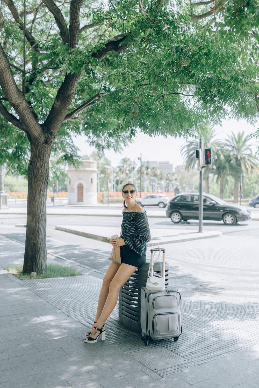 woman_wearing_sunglasses_sitting_on_luggage